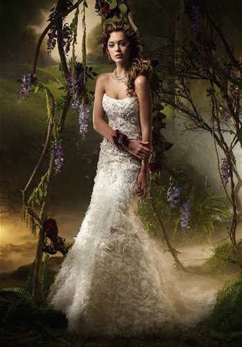Gown features curved neckline, beading, embroidery, and tufted skirt.